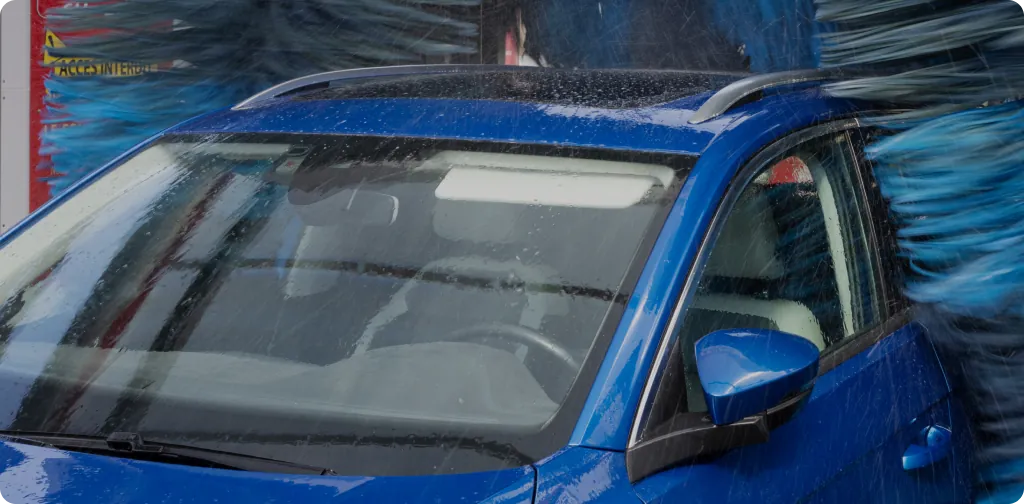 Blue SUV in the Turbo Tide wash tunnel between soft-cloth brushes